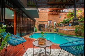 a pool with two blue chairs and a potted plant at Manor on the Hill in Krugersdorp