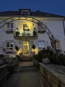 ein großes weißes Haus mit einem Bogen davor in der Unterkunft MarijaM-Haus in Badenweiler