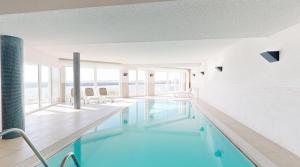 a swimming pool with a view of the ocean at Ferienwohnung Seeloge im Bollwark Olpenitz in Olpenitz
