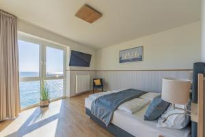 a bedroom with a bed and a large window at Ferienwohnung Seeloge im Bollwark Olpenitz in Olpenitz
