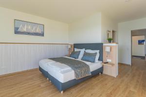 a bedroom with a large bed in a room at Ferienwohnung Seeloge im Bollwark Olpenitz in Olpenitz