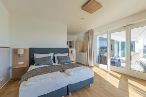 a bedroom with a large bed and a balcony at Ferienwohnung Seeloge im Bollwark Olpenitz in Olpenitz +25 photos