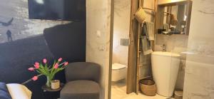 a bathroom with a chair and a sink and a mirror at Le Petit Trianon et le Charme des Suites in Nice +25 photos