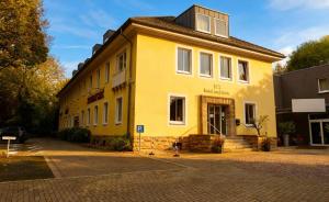 a yellow building on the side of a street at Hotel Ambiente in Dortmund
