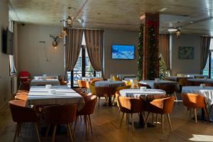 a restaurant with tables and chairs and a christmas tree at IREPALACE Goderdzi in Goderdzi