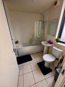a bathroom with a tub and a toilet and a sink at Cozy Room , prime location in Dublin