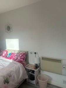a bedroom with a bed and a white wall at Cozy Room , prime location in Dublin