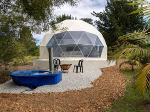 a dome house with a fountain in a yard at Five Elements Resort - Dome Glamping Tent in Harkerville