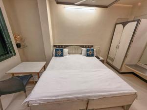 a large bed in a room with a chair at Hotel Kinara Lodge in Jāmkhed
