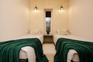two beds in a room with green and white blankets at Bukowe Wzgórza in Trzebniów