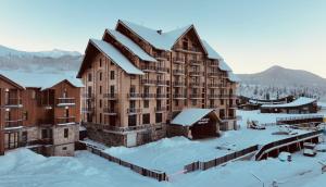 a large building with snow on the ground at IREPALACE Goderdzi in Goderdzi