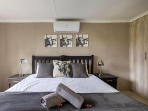 a bedroom with a bed with a towel on it at Five Elements Resort - Nguni Cabin in Harkerville