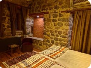 a bedroom with a bed and a brick wall at MiNKA HOUSE in Hisarcık