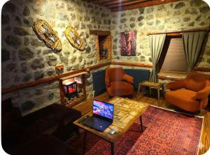 a living room with a laptop on a table and a fireplace at MiNKA HOUSE in Hisarcık