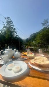 a wooden table topped with white dishes and tea pots at Ella 78 Resort in Ella