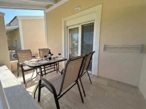 a dining room with a table and chairs on a patio at Hestia ApartHotel in Roda +13 photos