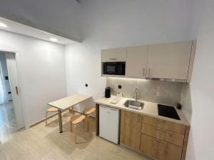 a small kitchen with a sink and a table at Hestia ApartHotel in Roda