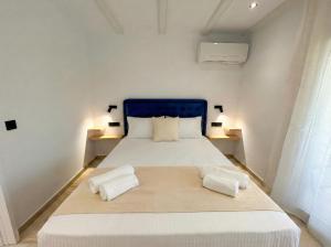 a bedroom with a large bed with two towels on it at Hestia ApartHotel in Roda
