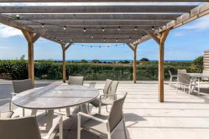 a wooden pergola with a table and chairs on a patio at Maison des Landes - Accessible Hotel in St. Ouen's +26 photos