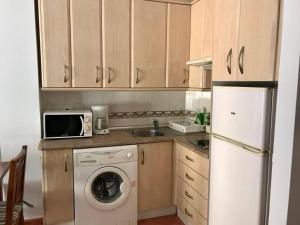 a kitchen with a white refrigerator and a washing machine at Jeribel PlayA1 in Fuengirola