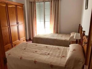 two twin beds in a bedroom with a window at Jeribel PlayA1 in Fuengirola