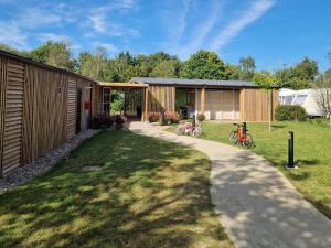 a house with a garden and a driveway at Camping les Chalands Fleuris in Saint-André-des-Eaux