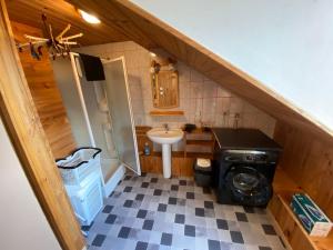 a small bathroom with a sink and a washing machine at Loft des Cimes - Evasion en montagne avec local vélo privé in Cornimont +34 photos