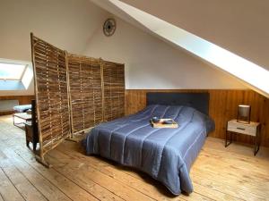 a bedroom with a bed with a wooden floor at Loft des Cimes - Evasion en montagne avec local vélo privé in Cornimont