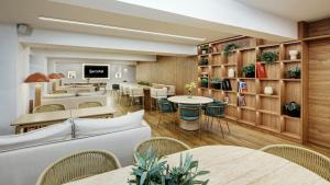 a restaurant with tables and chairs in a room at Sercotel HMO Martina in Granada