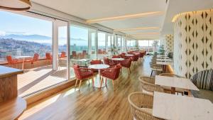 a restaurant with tables and chairs and large windows at Sercotel HMO Martina in Granada