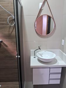 a bathroom with a sink and a mirror on the wall at Casa Lovato in Arroio do Sal