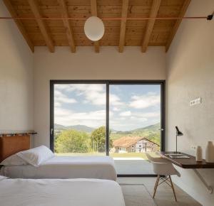 ein Schlafzimmer mit zwei Betten und einem großen Fenster in der Unterkunft ATEALAIA Kortezubi in Forua