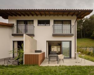 ein Haus mit einer Terrasse mit Tisch und Stühlen in der Unterkunft ATEALAIA Kortezubi in Forua