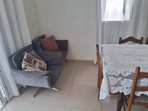 a living room with a chair and a table at Casa Lovato in Arroio do Sal