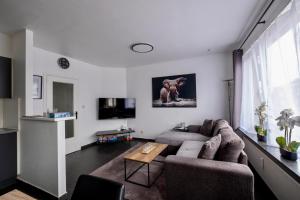 a living room with two couches and a tv at Appartement Guillaume in Blankenberge