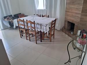 a dining room table with chairs and a white table cloth at Casa Lovato in Arroio do Sal