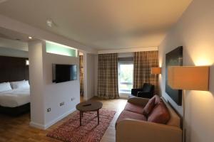 a hotel room with a couch and a bed at Park Inn by Radisson Birmingham Walsall in Walsall