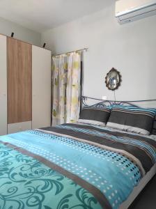 a bedroom with a large bed with a blue comforter at To Pefko in Perdika +6 photos