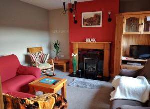 a living room with red walls and a fireplace at Wooly Lodge in Westport