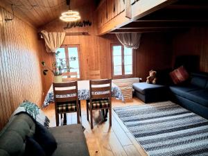 a living room with a couch and a table and chairs at Lake view Chalet , Drligen in Därligen