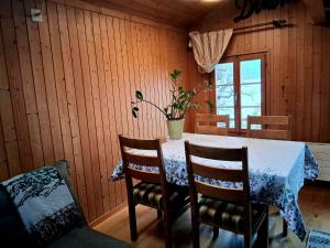 a dining room table with chairs and a potted plant at Lake view Chalet , Drligen in Därligen +3 photos