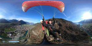 a man riding a parachute over a mountain at Lake view Chalet , Drligen in Därligen