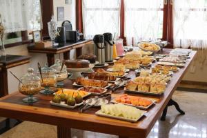 a long table filled with different types of food at Pousada Costa Rielli in Águas de Lindoia