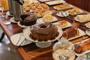 a table with different types of pastries and cakes at Pousada Costa Rielli in Águas de Lindoia