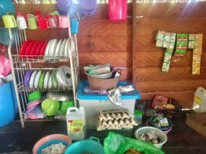 a kitchen with dishes and other kitchen utensils at Or Mandira Homestay in Pulau Penemu