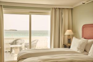 a bedroom with a bed and a view of the ocean at Sola Strand Hotel in Sola