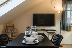 a dining room table with two cups and a television at V&D 7 by Mountain ways in Rokytnice nad Jizerou