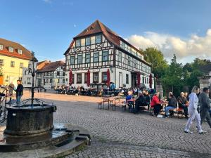Eine Gruppe von Menschen, die vor einem Gebäude sitzen in der Unterkunft Krone Post in Gersfeld