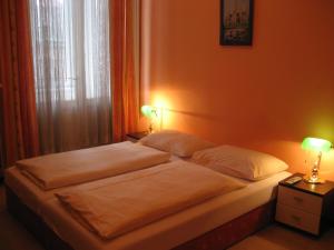 a bed in a bedroom with two lamps on it at Pension Schottentor in Vienna