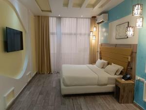 a hotel room with a bed and a television at Hôtel Copacabana Kribi in Kribi